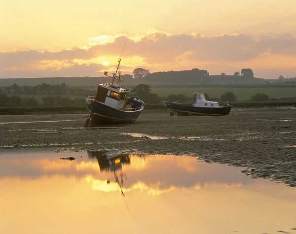 Fishing boat at sunset on the Aln estuary at low tide, Alnmouth, Northumberland
