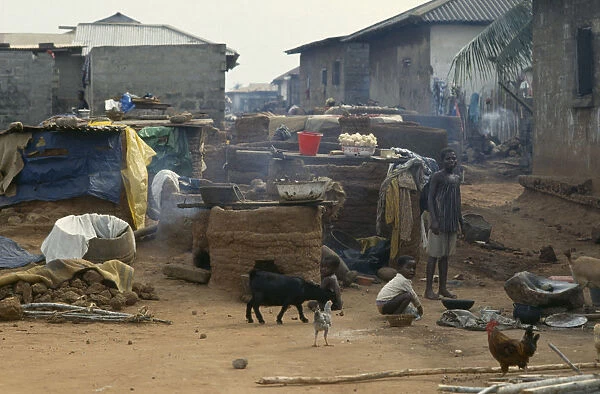 20075485. GHANA Village Scene Outside ovens in village near Accra with children goats