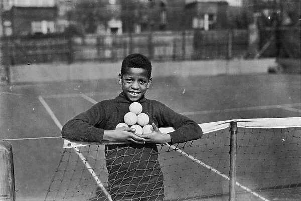 Ball Boy. 26th March 1928: A ball boy holding tennis balls at Hampstead Hard Court Club