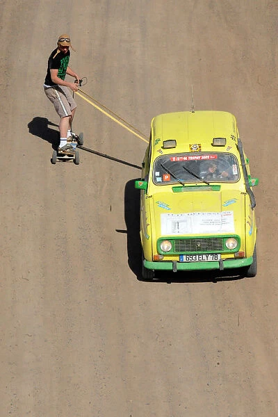 A man on a skate board is pulled by a 4L before the stage from Boudnib to Merzouga