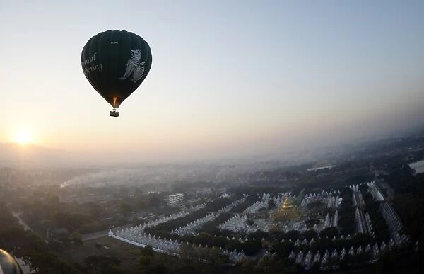 This photo taken on February 5, 2014 shows a hot air balloon flying over a temple