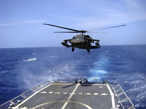 An Army UH-60 Black Hawk helicopter landing aboard the USS Underwood off the coast