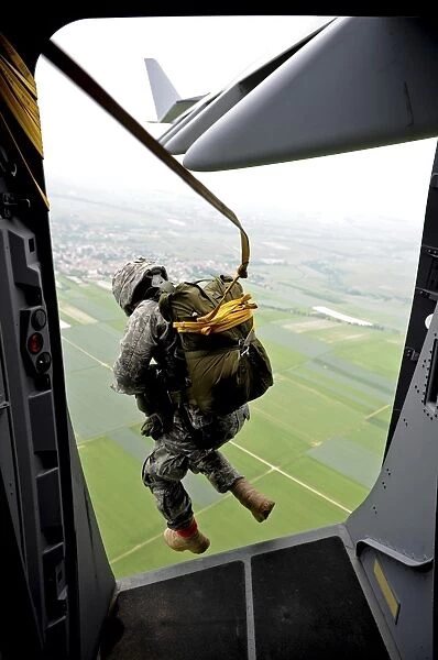 A paratrooper executes an airborne jump out of a C-17 Globemaster III