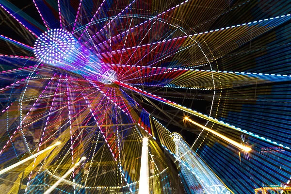 Colourful Lights Of A Moving Ferris Wheel At Nighttime; Calgary, Alberta, Canada