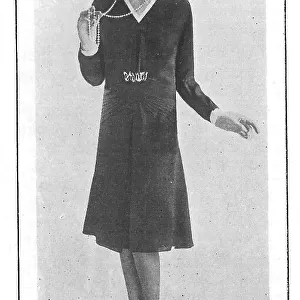 Model wearing a short-skirted afternoon frock and a string of pearl beads Date: 1930