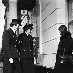 Two women police officers and woman with suitcase