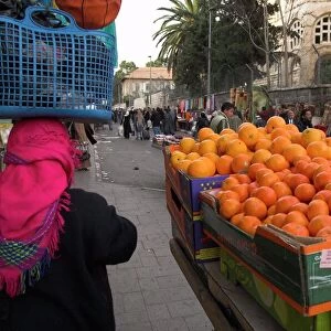 Palestinian woman in colourful scarf and carrying bag