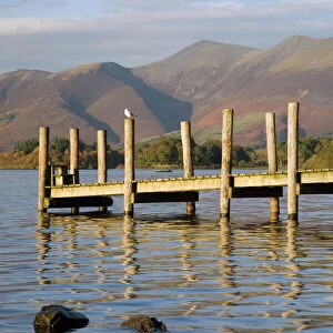 Wooden jetty at Barrow Bay landing on Derwent Water looking north to Skiddaw in autumn
