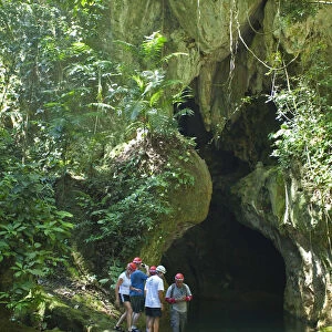 Central America, Belize, Cayo, a guide escorts tourists into the Actun Tunichil Muknal