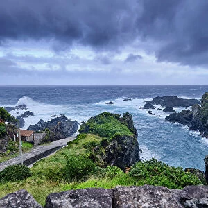 The northeast coast of Flores island, at Boqueirao, on a stormy day. The ramp to pull the sperm whales on the left, by the sea. Azores islands, Portugal