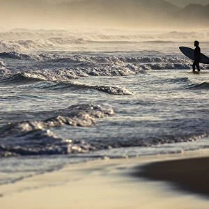 A surfer observes sea at Playa del Puntal, Santander, Cantabria, Spain