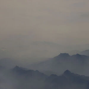 Heavy smog is seen among the mountains from an aircraft