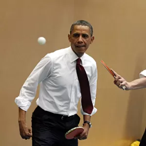 U. S. President Barack Obama plays table tennis against students with British Prime
