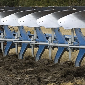 Close-up of eight furrow reversible plough, ploughing stubble field, Sweden, autumn