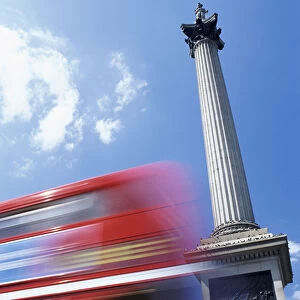 Double Decker Bus Driving past Nelsons Column on Trafalgar Square, Tourists Sitting on Steps, London, UK