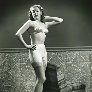 Young woman in underwear and stockings posing indoors, (B&W)