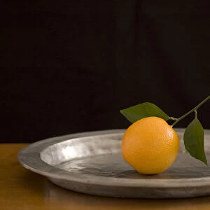 Orange with leaves on pewter charger credit: Marie-Louise Avery / thePictureKitchen