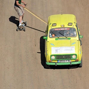 A man on a skate board is pulled by a 4L before the stage from Boudnib to Merzouga