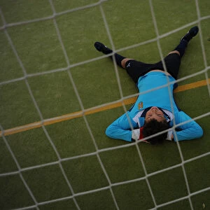 A young player of the Ronda Union Deportiva football club rests on the field during