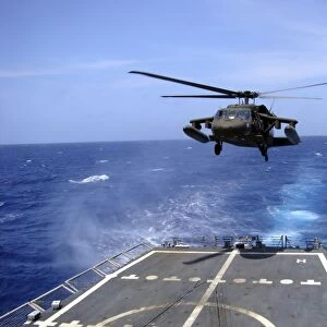 An Army UH-60 Black Hawk helicopter landing aboard the USS Underwood off the coast