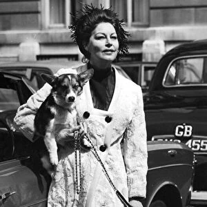 Ava Gardner carrying a pet corgi as she arrives on location set in London - January 1970