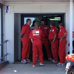 Ferrari team members rush to the medical centre for news on Michael Schumacher