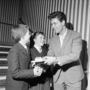 Singer Cliff Richard seen here presenting a school prize of three books to Carol
