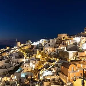Stunning night view of fabulous caldera view, picturesque village of Oia with traditional white houses under sunset. Amazing travel vacation landscape