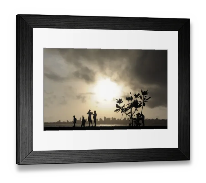 Framed Print : TOPSHOTS Indians stroll near the seafront as dark clouds gather over city skyline