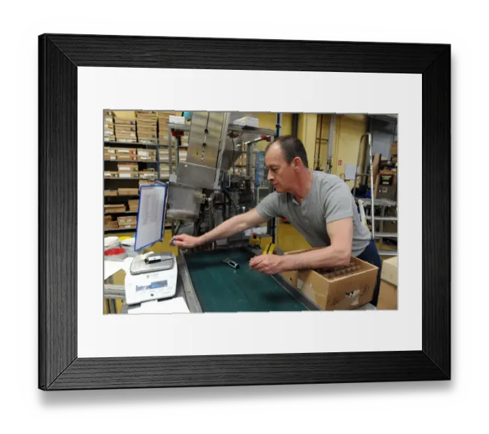 Framed Print : An employee weighs tubes of oil paint in a workshop at the Raphael-Isabey-Sennelier