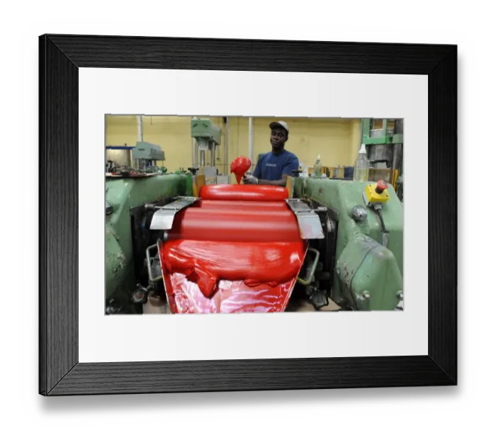 Framed Print : An employee pours oil paint in a workshop at the Raphael-Isabey-Sennelier factory in Saint-Brieuc