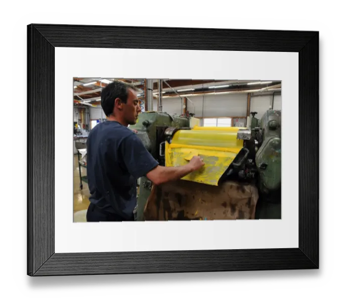 Framed Print : An employee scratches the residue of oil paint in a workshop at the Raphael-Isabey-Sennelier