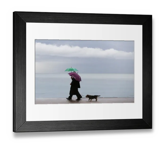 Framed Print : People walk on the Promenade des Anglais during a rainy afternoon, on November 25 Framed Print : People walk on the Promenade des Anglais during a rainy afternoon, on November 25
