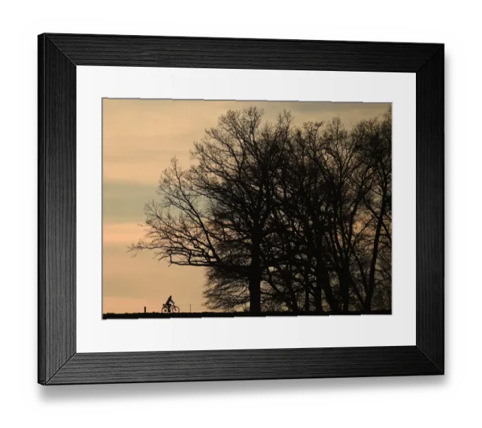 Framed Print : A cyclist passes along a country lane near the small Bavarian village of Puchheim near Munich