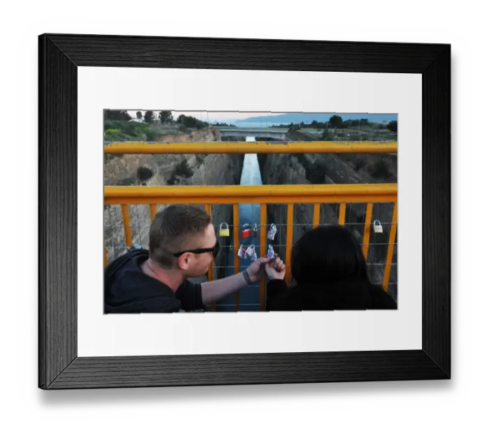 Framed Print : A couple looks at a love lock they attached to a bridge overlooking