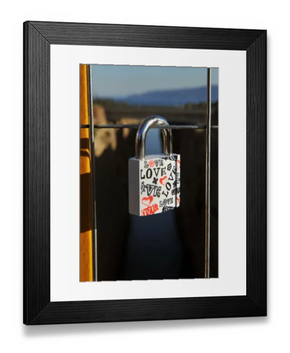 Framed Print : A view of a love lock attached by a couple on a bridge overlooking