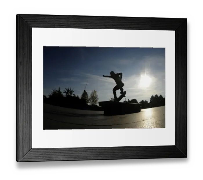 Framed Print : A youth performs a trick on his skateboard during a warm autumn sunny day on October 4 Framed Print : A youth performs a trick on his skateboard during a warm autumn sunny day on October 4
