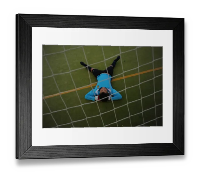 Framed Print : A young player of the Ronda Union Deportiva football club rests on the field during Framed Print : A young player of the Ronda Union Deportiva football club rests on the field during