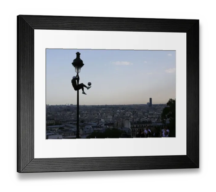 Framed Print : Iya Traore, a former professional football player, holds on to a lamppost as he performs Framed Print : Iya Traore, a former professional football player, holds on to a lamppost as he performs