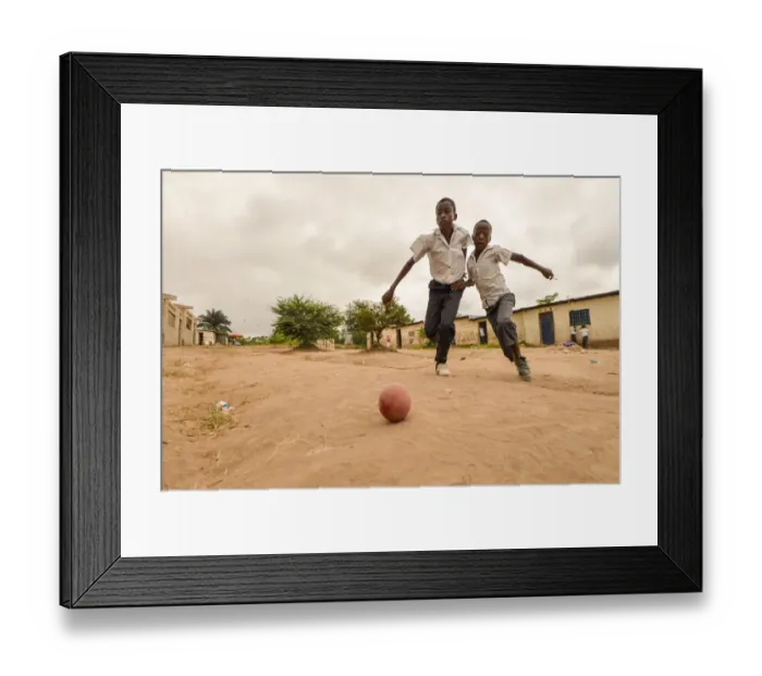 Framed Print : Children play football in the streets of the Kinsuka neighbourhood in the city of