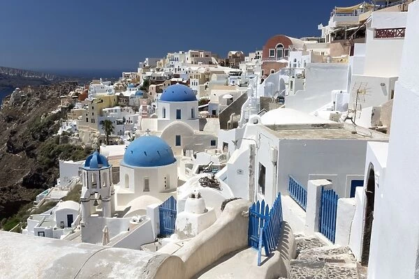 Classic view of the village of Oia with its blue domed churches and colourful houses