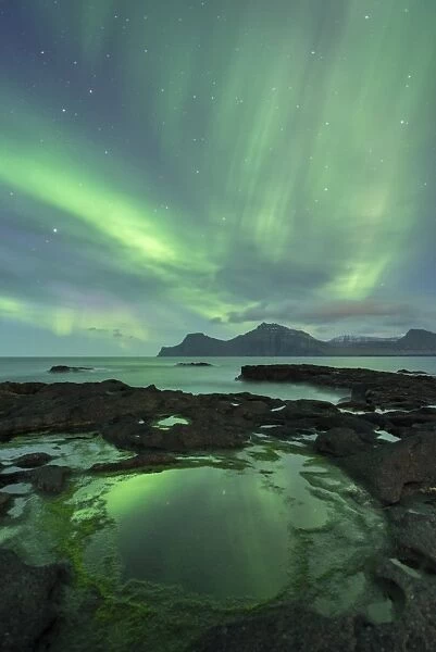 Aurora Borealis above the island of Kalsoy, photographed from the coastline of Gjogv