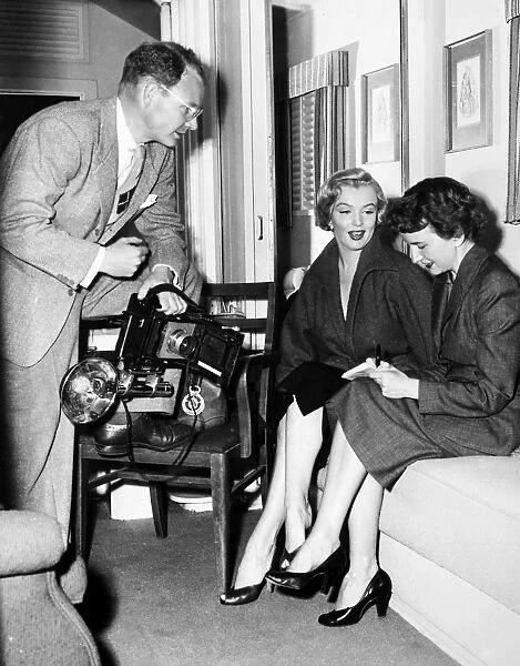 MARILYN MONROE (1926-1962). American cinema actress. Monroe in her dressing room at Fox Studios with journalist Aline Mosby and photographer George Long, 1952