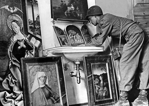 WWII: STOLEN ART, 1945. An American serviceman examining paintings recovered
