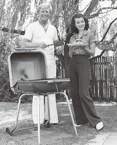 Couple having a barbecue in their backyard