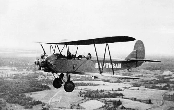 World war 2, a partisan airplane (polikarpov po-2) flying over leningrad territory, the word partisan is written on the side of the plane