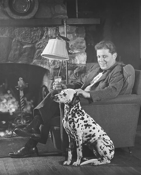 Man with dalmatian sitting at fireplace (B&W)