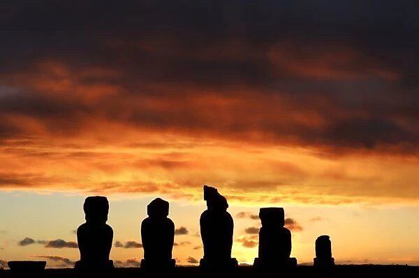 Chile-Moais-Sunset. The sun sets behind Moais -- stone statues of the Rapa