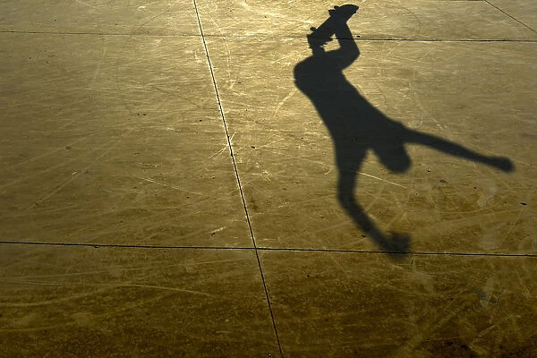 Colombia-Feature. The shadow of a young man jumping on a skateboard is