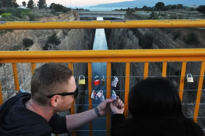 Framed Print : A couple looks at a love lock they attached to a bridge overlooking
